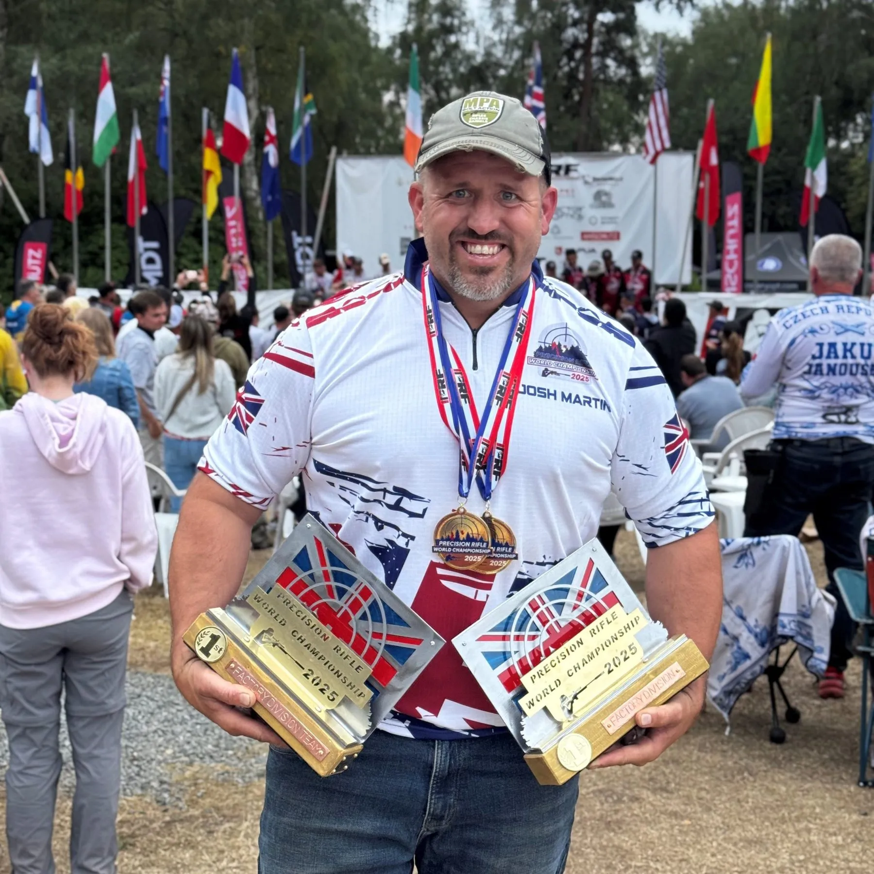 Josh Martin holding his trophies and medal at the IPRF Rimfire World Championships